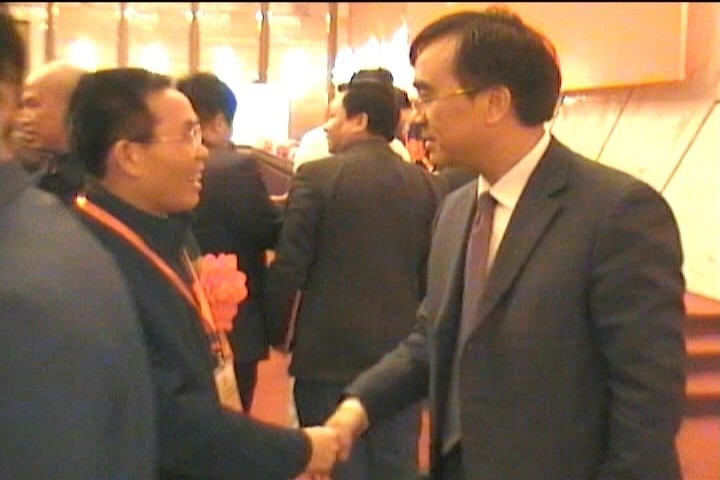 中华中医药学会曹正逵副秘书长与李穆亲切握手